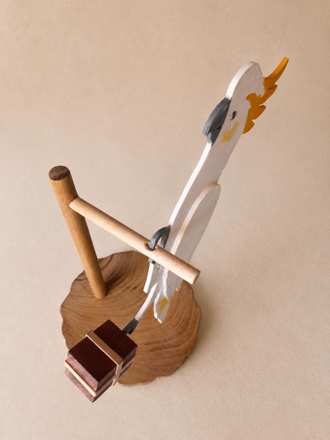 Kakadu Skulptur – handgefertigte tropische Vogelfigur aus Holz mit Paket-Detail